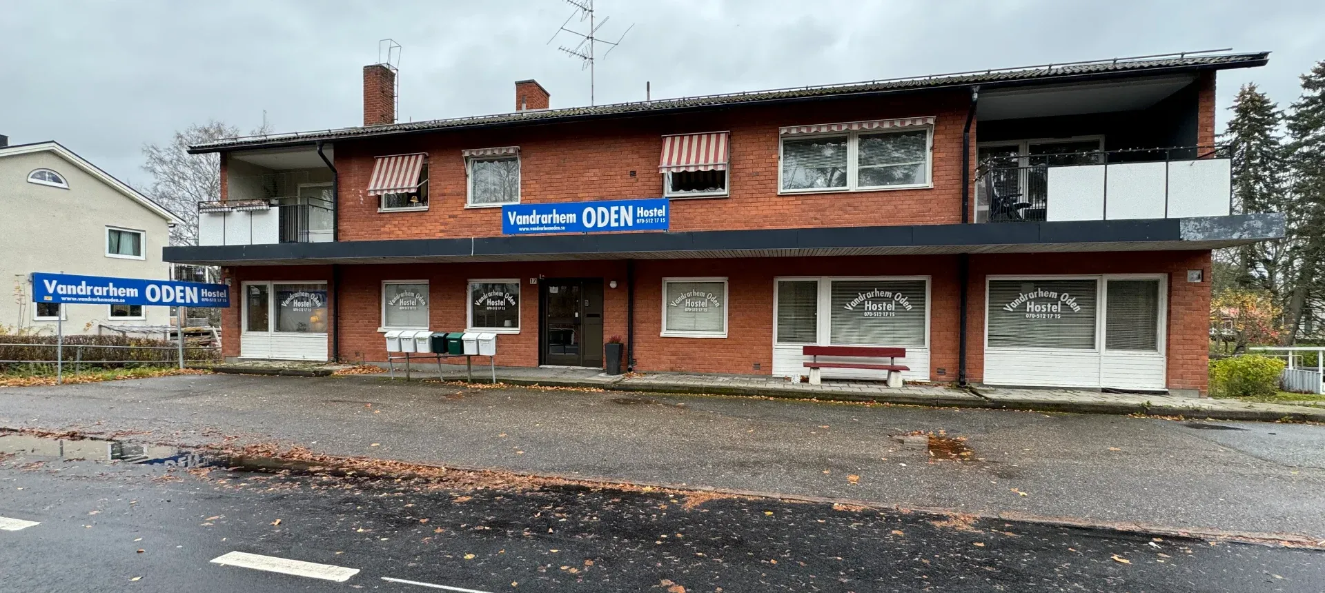 Vandrarhem Oden på Örebrovägen 17 – tegelhus med blå skylt "Vandrarhem ODEN Hostel"